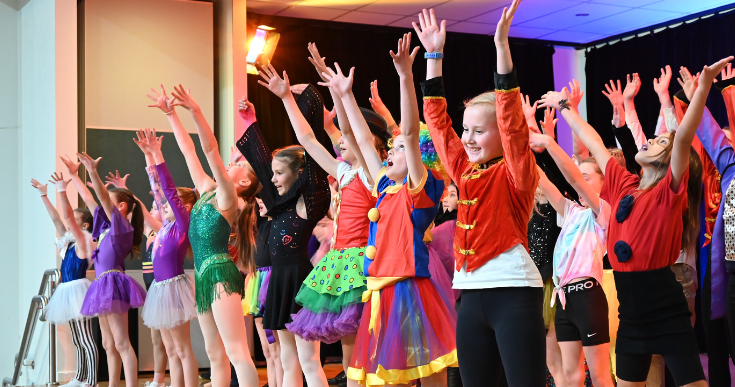 Children in costumes performing on stage