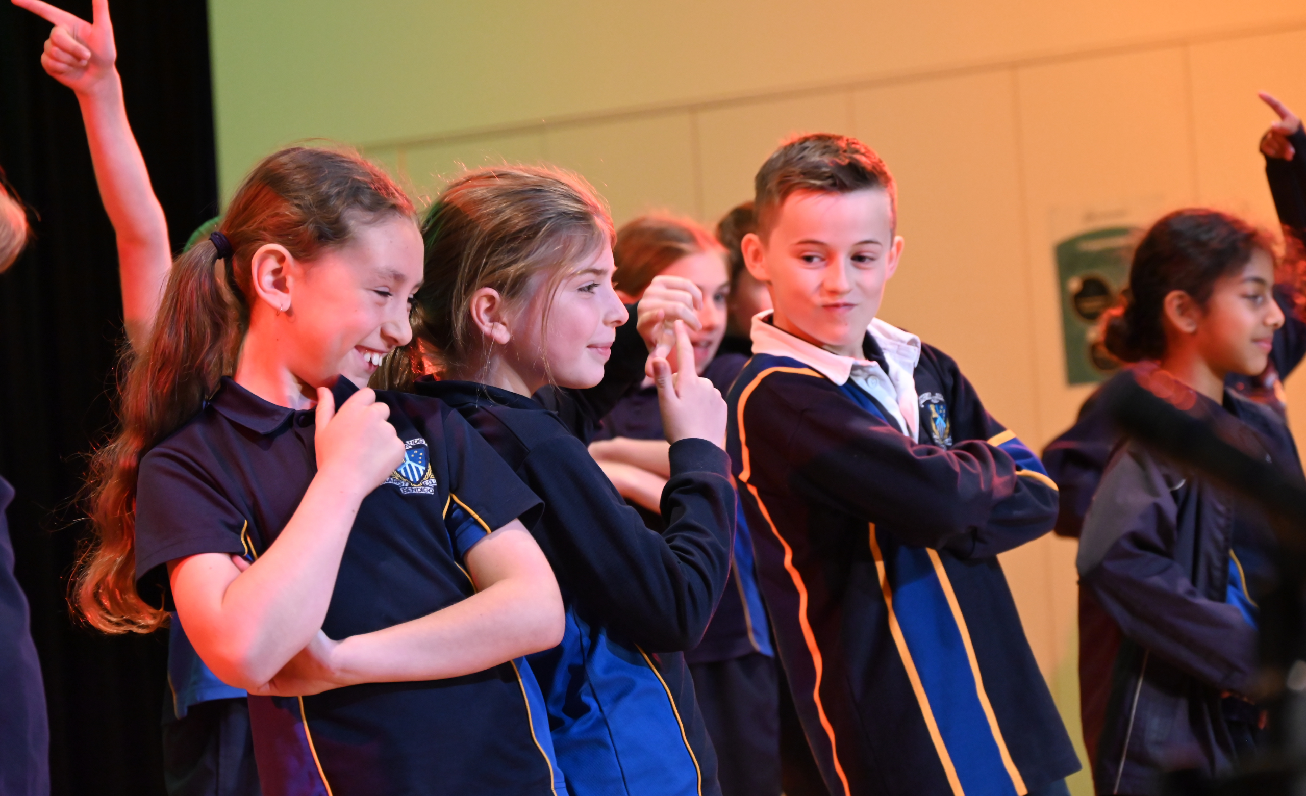 Primary school children performing in navy uniform with yellow stripes