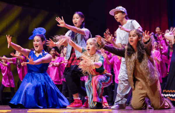 Young performers in costumes on stage